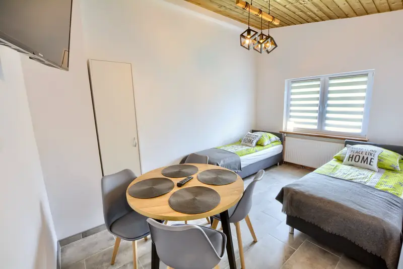 Apartament 4 – jasny pokój z dwoma łóżkami pojedynczymi i okrągłym stołem